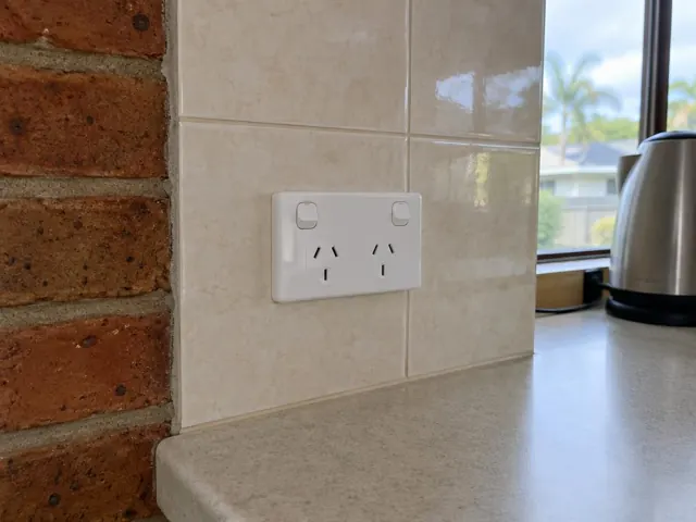 Double power point on a tiled kitchen splashback above a benchtop in Coombabah
